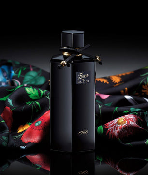 Black Gucci perfume bottle on a colorful fabric background