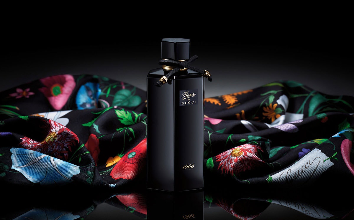 Black Gucci perfume bottle on a colorful fabric background