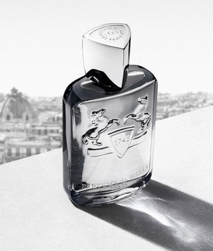 Perfume bottle with brand logo on a light surface with blurred background
