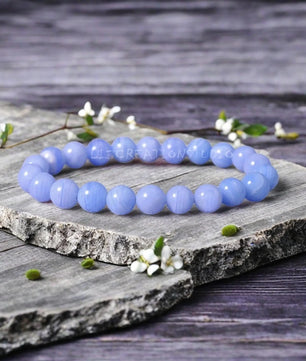 Blue beaded bracelet on a wooden surface with flowers