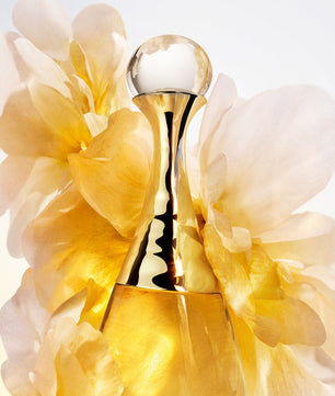 Gold perfume bottle with flowers on a light background