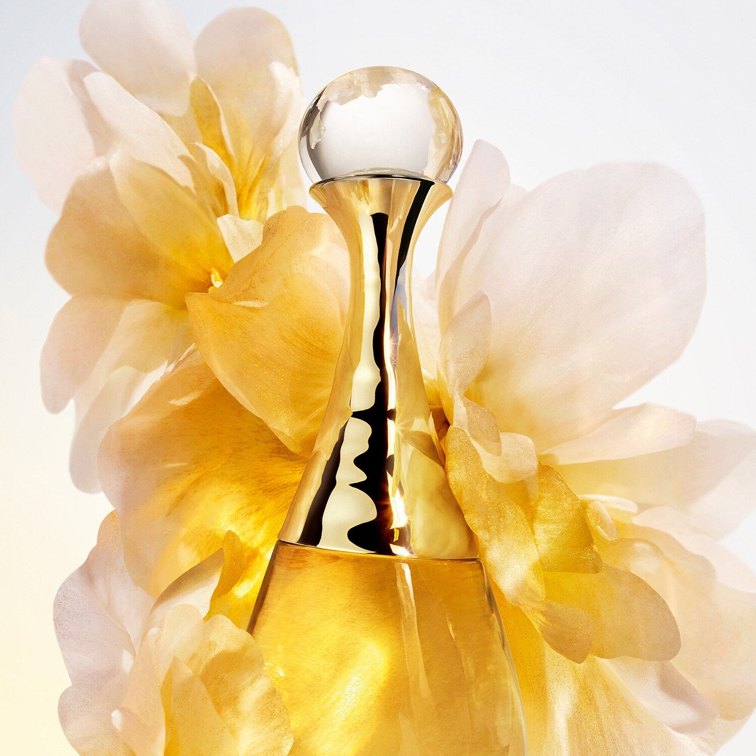 Gold perfume bottle with flowers on a light background