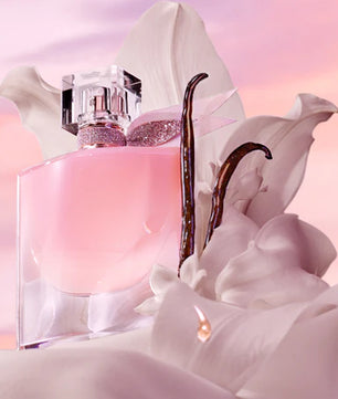 Pink perfume bottle with a decorative cap on a soft pink background