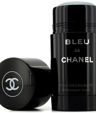 Chanel Bleu de Chanel stick deodorant in a glossy black cylindrical container, shown with the cap removed and placed beside it on a white background.