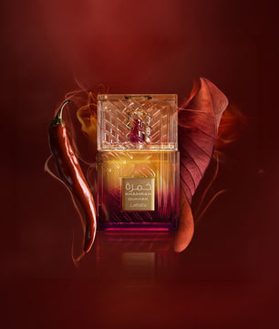Perfume bottle with a red leaf and chili pepper on a dark background