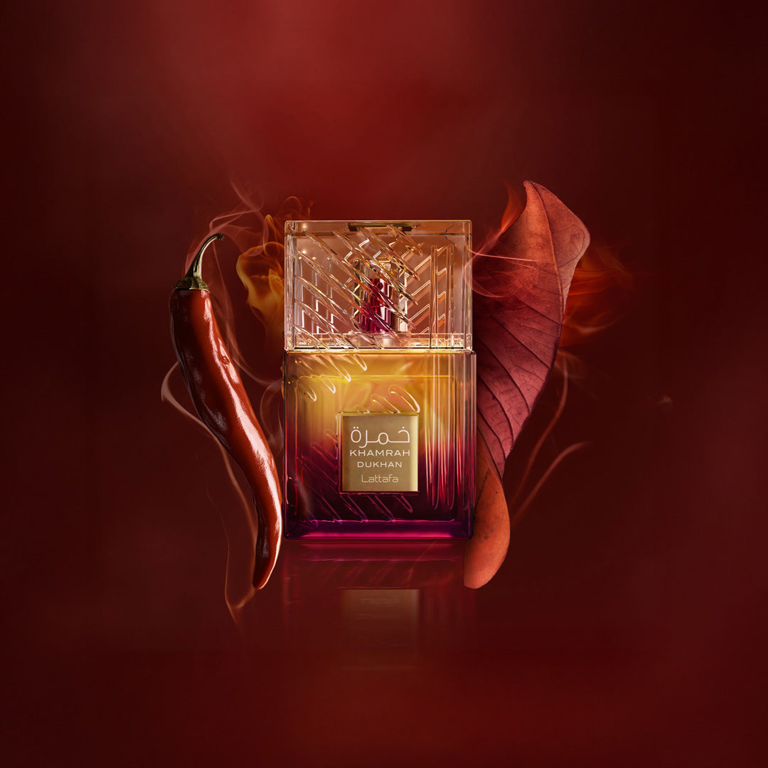 Perfume bottle with a red leaf and chili pepper on a dark background