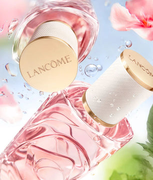 Lancome perfume bottles with pink flowers and water droplets on a light blue background