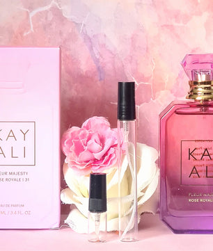 Kay Ali perfume set with bottle, box, and flowers on a pink marble background