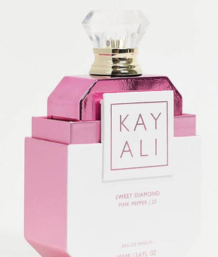 Pink and white perfume bottle with 'KAY ALI' branding on a light pink background