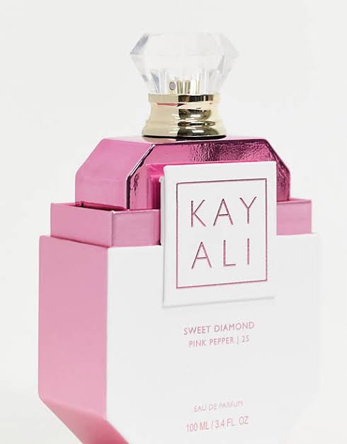 Pink and white perfume bottle with 'KAY ALI' branding on a light pink background