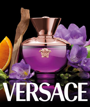 Versace perfume bottle with purple flowers, orange, and lime on a black background