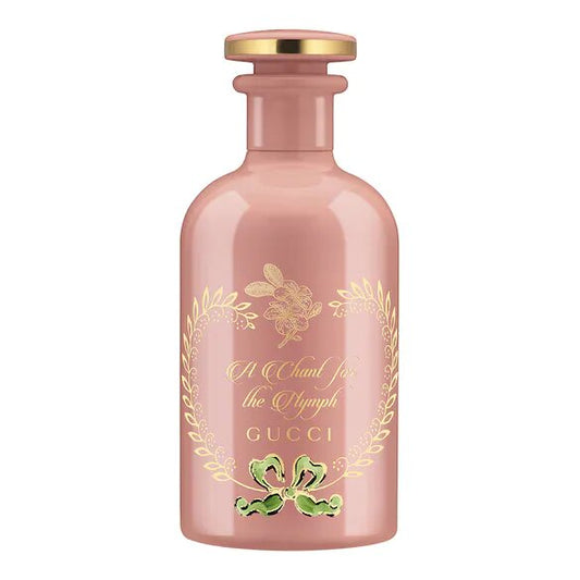 A pink GUCCI Eau De Parfum bottle with a gold cap and floral design around the label.